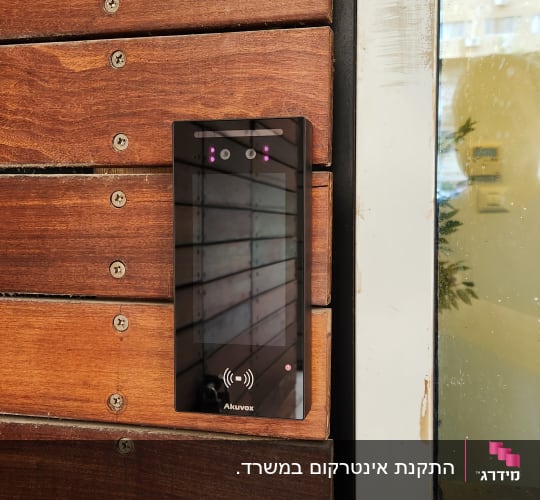 אינטרקום דיגיטלי מותקן על קיר עץ